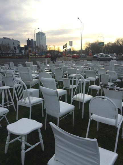 White chairs at dusk where people can sit to pay their respects.