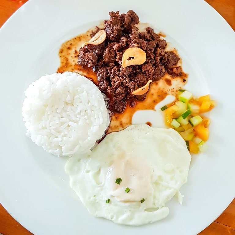 Beef tapa with steamed rice and sliced tomato and cucumber