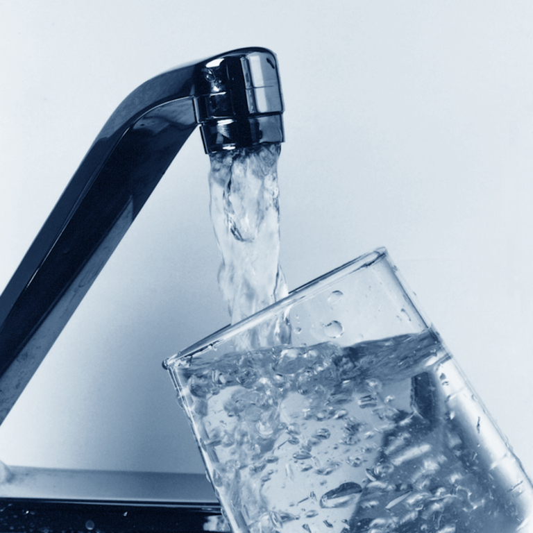 Water pouring from a faucet into a clear glass cup. (15054813052)