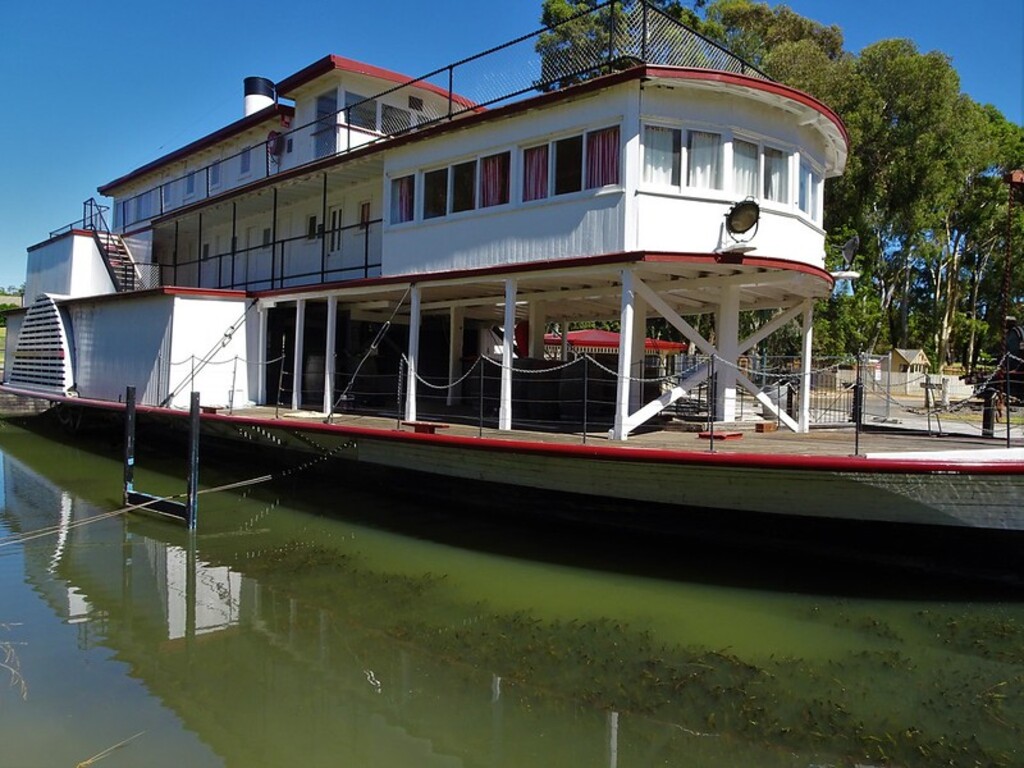 Swan Hill. The Gem paddle steamer with reflections in a dock near the River Murray.