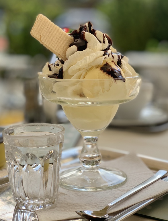 Ice cream with whipped cream, chocolate syrup, and a wafer (cropped)
