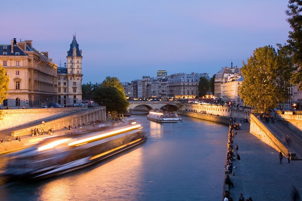 Cruises buzz along the Seine river on a calm evening
