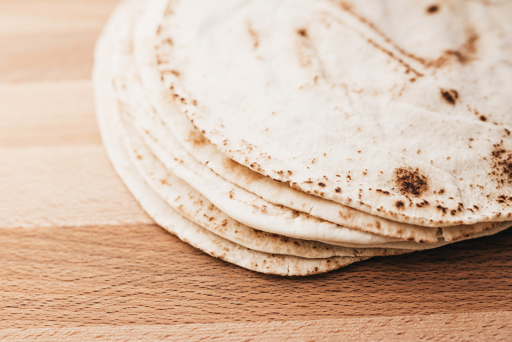 Stack of pita bread on wooden board