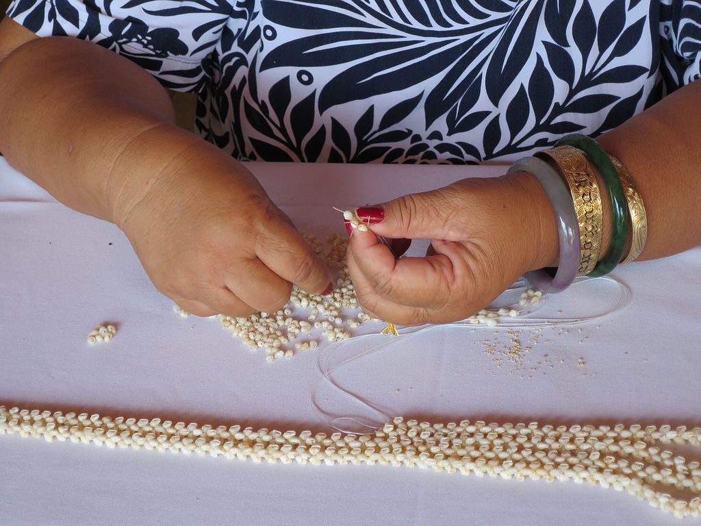Lady from Niihau making a shell lei