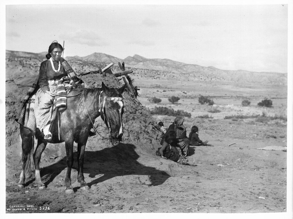 View of a Navajo Indian maiden on a pony in front of a hogan, ca.1901 (CHS-3236)