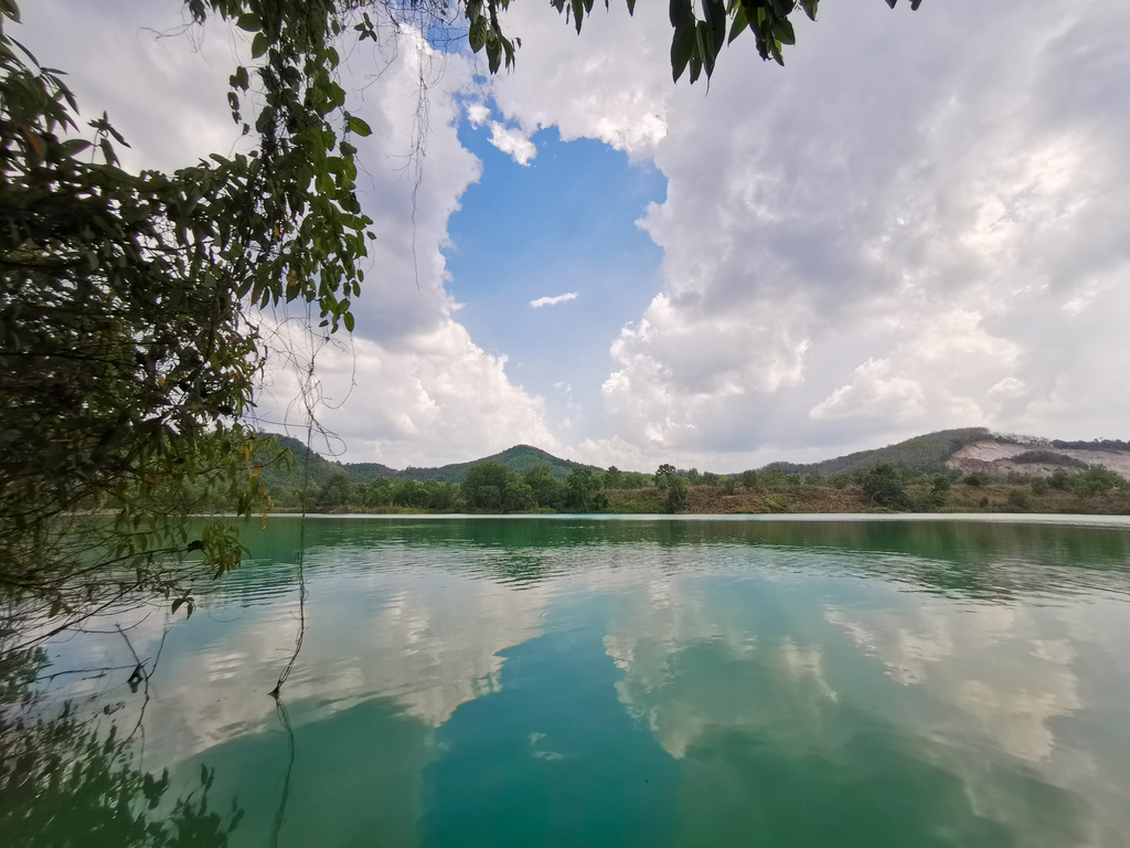 A beautiful green lake under the blue sky and clouds in Songkhla, Thailand