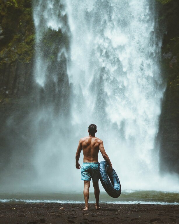Man in front of waterfall