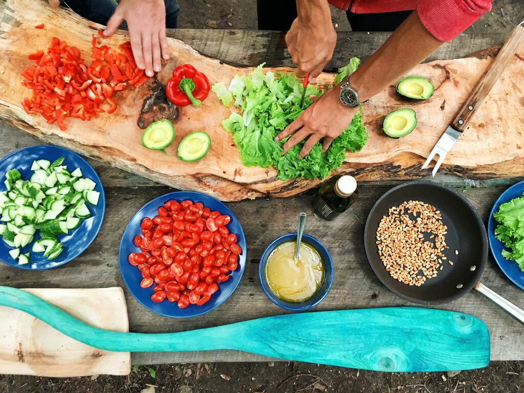 Person slicing green vegetables