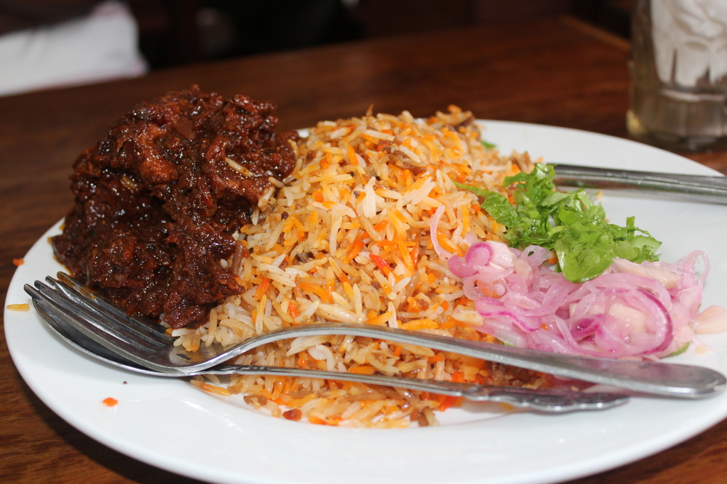 Mutton Biriani with sliced onion rings and lettuce